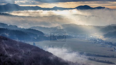 Téléchargez les photos : Paysage montagneux avec vallées brumeuses à la lumière dramatique au coucher du soleil. Nord-ouest de la Slovaquie, Europe. - en image libre de droit