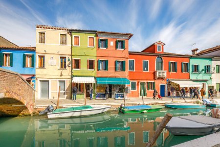Foto de BURANO, ITALIA - 3 DE MARZO DE 2023: La isla cerca de Venecia con canales entre casas coloridas. - Imagen libre de derechos