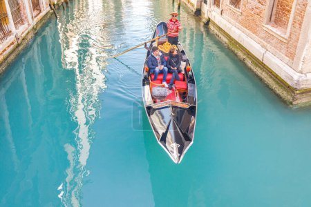 Photo for VENICE, ITALY - MARCH 4, 2023: Gondola with passengers sailing on canals. - Royalty Free Image