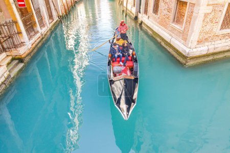 Foto de VENECIA, ITALIA - 4 DE MARZO DE 2023: Góndola con pasajeros navegando por los canales. - Imagen libre de derechos