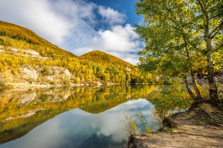 Téléchargez les photos : Paysage d'automne avec reflet de collines colorées dans le lac. Carrière inondée près du village Sutovo en Slovaquie, Europe. - en image libre de droit