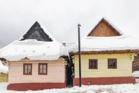 Téléchargez les photos : Architecture folklorique dans un paysage hivernal enneigé. Village de Vlkolinec avec des maisons en bois colorées historiques, Slovaquie Europe. - en image libre de droit