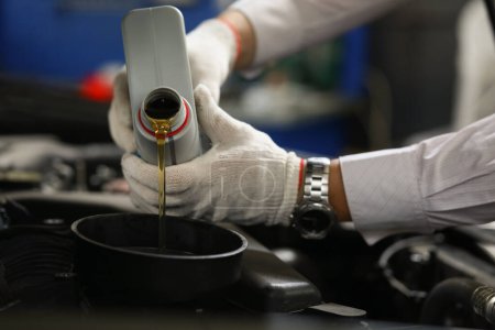 Photo for Hands of mechanic pours oil into car engine. Automotive quality oil in the engine concept - Royalty Free Image