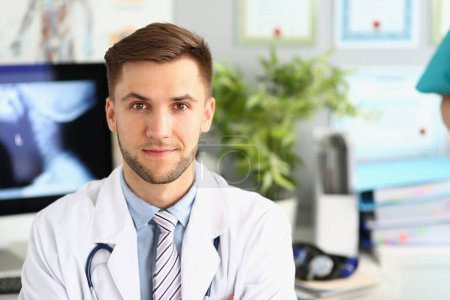 Photo for Portrait of young handsome male doctor in clinic. Medical services and insurance concept - Royalty Free Image