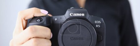 Photo for Tbilisi, Georgia - July 26, 2022: Person holding modern Canon EOS R5 camera closeup in hand. Canon mirrorless cameras - Royalty Free Image