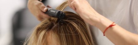 Photo for Pulling strands of hair with professional iron care. Keratin straightening and hair restoration - Royalty Free Image