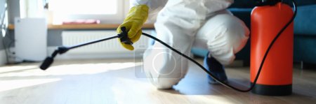 Photo for Isinfection of premises from insects and rodents with chemicals. Plumber spray on the background of apartment and pest control - Royalty Free Image