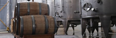 Téléchargez les photos : Huge tanks in wine cellars and wooden barrels of wine or alcohol. Production of elite collection wine concept - en image libre de droit