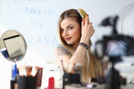 Foto de Happy beautiful woman looking at camera making beauty vlog. Remote training in makeup and hairstyles - Imagen libre de derechos