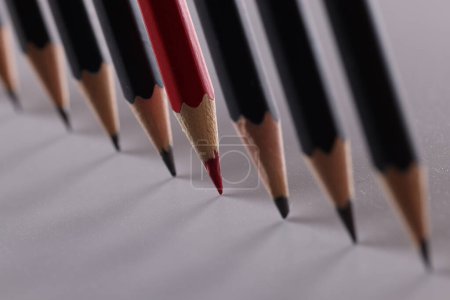 Téléchargez les photos : Un crayon rouge est un ensemble d'homologues noirs identiques. Caractère unique des idées d'affaires et approche créative créative - en image libre de droit