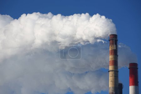 Nubes tóxicas de humo salen de la chimenea de la fábrica. Concepto de CHP y chimeneas fumadoras