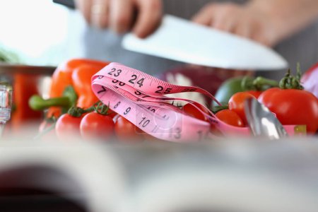 Téléchargez les photos : Coupe de légumes frais et ruban à mesurer dans la cuisine. Alimentation végétarienne et concept nutritionnel approprié - en image libre de droit