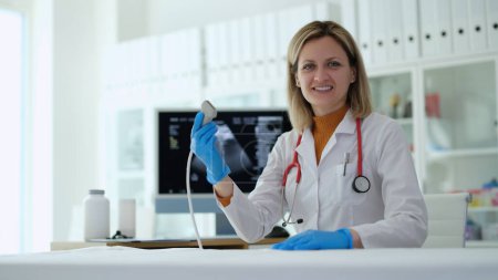 Doctora sosteniendo sonda ultrasónica en la clínica. Diagnóstico precoz del embarazo concepto de examen ecográfico