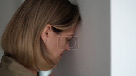 Foto de Mujer deprimida cansada golpeando su cabeza contra la pared. Concepto de situaciones sin esperanza - Imagen libre de derechos
