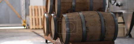 Téléchargez les photos : Winery and cognac factory with steel fermentation tanks and wooden barrels for aging process. Food industry and winemaking concept - en image libre de droit