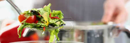 Téléchargez les photos : Chef a servi une assiette de salade de légumes frais en cuisine. Préparation de salade vitaminée végétarienne - en image libre de droit
