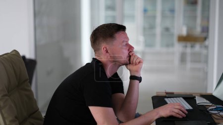 Foto de Pensativo hombre de negocios enfocado en trabaja en la computadora y lee en la pantalla. Gerente piensa mira al monitor con cara seria - Imagen libre de derechos