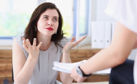 Woman business annoyed at confusion confusion pulling her hands from a lot of paper work does not understand how you can bring as many documents