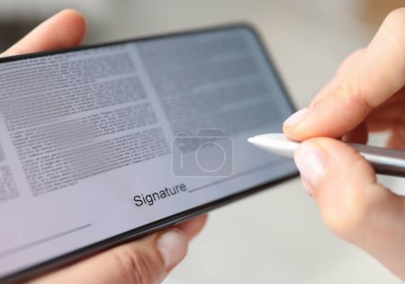 Person puts signature with stylus on contract screen of smartphone. Signature applications concept