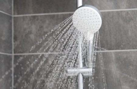 Duscharmatur, aus der Wasser ins Badezimmer fließt. Kontrastdusche für das Körperkonzept