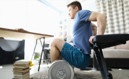 Foto de El hombre está haciendo ejercicios físicos en casa. Concepto de fitness y entrenamiento en el hogar - Imagen libre de derechos