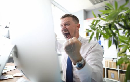 Photo for Crazy boss screams threatens with a fist and looks at camera against business office background. - Royalty Free Image