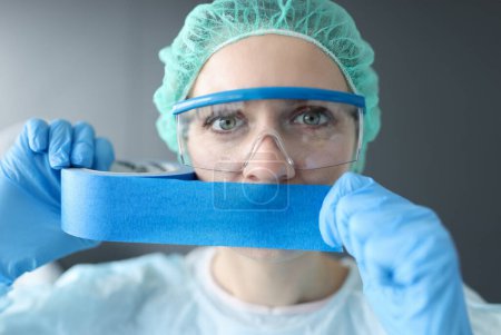 Photo for Woman doctor sealing her mouth with blue tape. Medical secrecy concept - Royalty Free Image