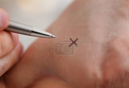 Téléchargez les photos : Homme faire x croix note avec stylo en argent à son bras pour garder à l'esprit dans le gros plan de bureau. Essayez de ne pas oublier de faire la liste concept - en image libre de droit