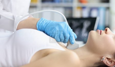 Téléchargez les photos : Woman receives ultrasound of thyroid gland from doctor. Thyroid hormones and thyroid gland - en image libre de droit