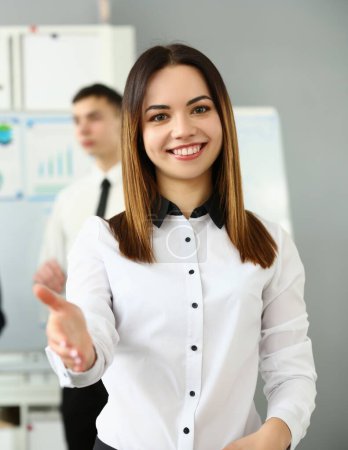 Téléchargez les photos : Smiling young business woman politely greets company office. Business consultant and team - en image libre de droit