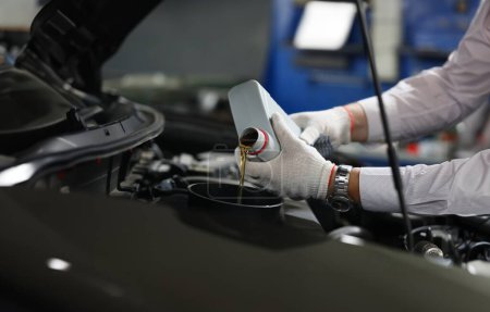Photo for Mechanical filling of oil into car in repair garage. Changing oil in engine of car service center - Royalty Free Image