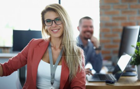 Foto de Portrait of happy businesswoman in glasses at workplace in office. Smiling confident young woman manager - Imagen libre de derechos