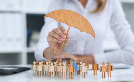 La mano femenina sostiene un paraguas en miniatura en la mano del tema del seguro de responsabilidad civil
