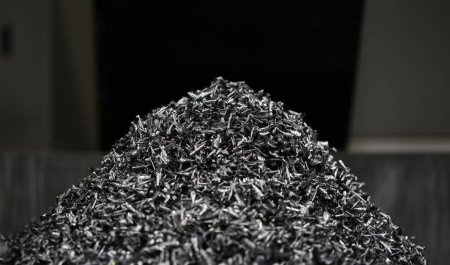 Close-up of pile of metallic shavings made after machinery work on milling or turning lathe for production special mechanical parts. Manual manufacturing process concept