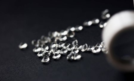 Téléchargez les photos : Dispersion de diamants étoiles blanches sur fond noir concept de bijoutier de table - en image libre de droit