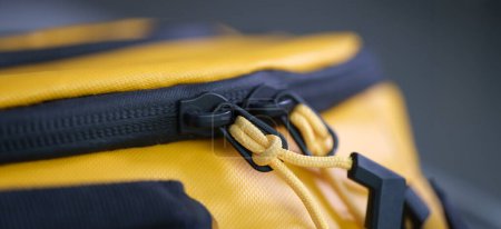 Téléchargez les photos : Fermeture éclair avec cordes sur sac à dos jaune gros plan. Accessoires pour sac à coudre concept - en image libre de droit