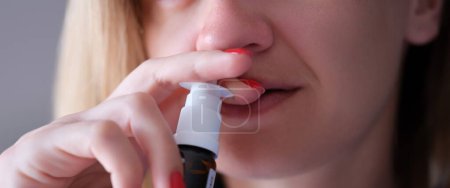 Photo for Woman instilling her nose with vasoconstrictor drops closeup. Acute sinusitis treatment concept - Royalty Free Image