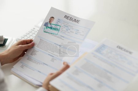 Photo for Hands holding a resume of a man, close-up. Job candidate selection. Recruitment agency, vacancy closing - Royalty Free Image