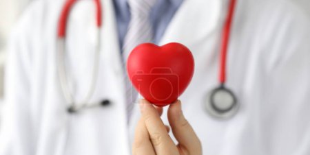 Arzt hält Herz mit schwarzem Punkt, Herzschrittmacher. Verringerung der Risiken Herzkrankheiten. Lassen Sie sich vom Facharzt beraten. Vorbereitung für die diagnostische Studie Herz. Bereitstellung medizinischer High-Tech-Versorgung