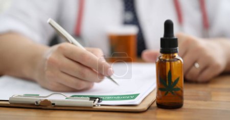 Closeup doctors hand writing prescription for hemp. Doctors prescribe cannabis for sleep disturbance. Hemp is part medication recommended for muscle spasms and epilepsy. Brain functioning