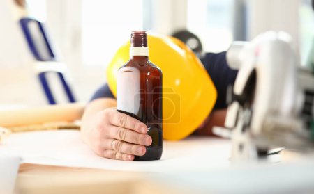 Arm eines betrunkenen Arbeiters mit gelbem Helm hält Schnapsflasche in der Hand. manuelle Arbeit Arbeitsplatz diy inspiration fix shop hard hat industrielle Ausbildung Beruf Karriere