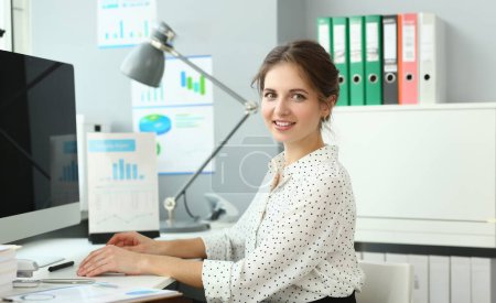 Beautiful smiling woman sitting in office looking in camera portrait