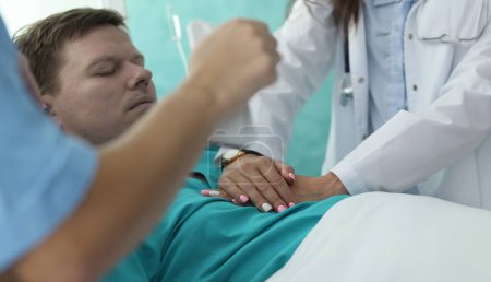 Hände Krankenschwester macht Herzmassage für den Mann in der Klinik. Diagnose und Behandlung von Herz-Kreislauf-Erkrankungen. Diagnose Herzinsuffizienz. Professionelle Teamärzte sorgen für qualifizierte Notfallversorgung