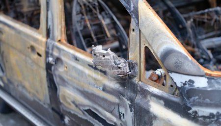 Photo for Door of burned-out car on street closeup. Riot civil protest and crime in city. Explosion fire result and car insurance concept - Royalty Free Image