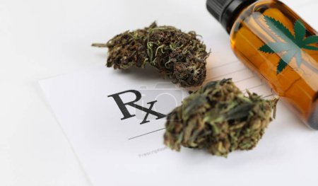 Dry marijuana leaves and cannabis oil jar lying on medical prescription closeup. Pharmacological business drug treatment concept