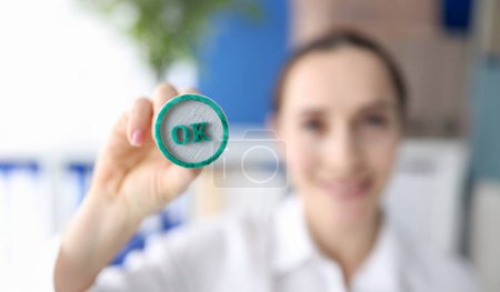 Photo for Woman holding green ink stamp OK in her hand closeup. - Royalty Free Image