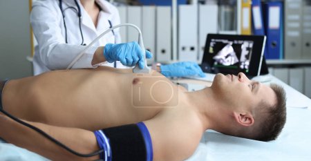 Arzt macht Herz-Ultraschall bei jungen männlichen Patienten in der Klinik. Diagnose und Behandlung von Herzkrankheiten
