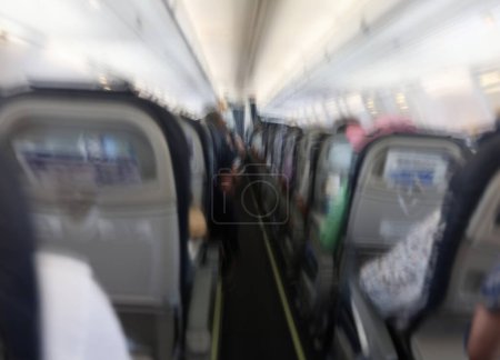 Passagiere, die in der Flugzeugkabine nach hinten fliegen, sehen verschwommenen Hintergrund. Konzept für Flugzeugturbulenzen