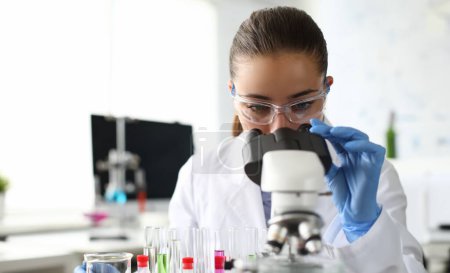 Photo for Close-up of scientist using microscope and test tubes. Laboratory assistant making analysing sample of medicines in research lab. Chemical experiments concept - Royalty Free Image