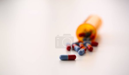 Tabletas dispersas tarro de color azul y rojo en la mesa de la píldora de laboratorio farmacéutico para la prescripción y el tratamiento de diversas enfermedades química
